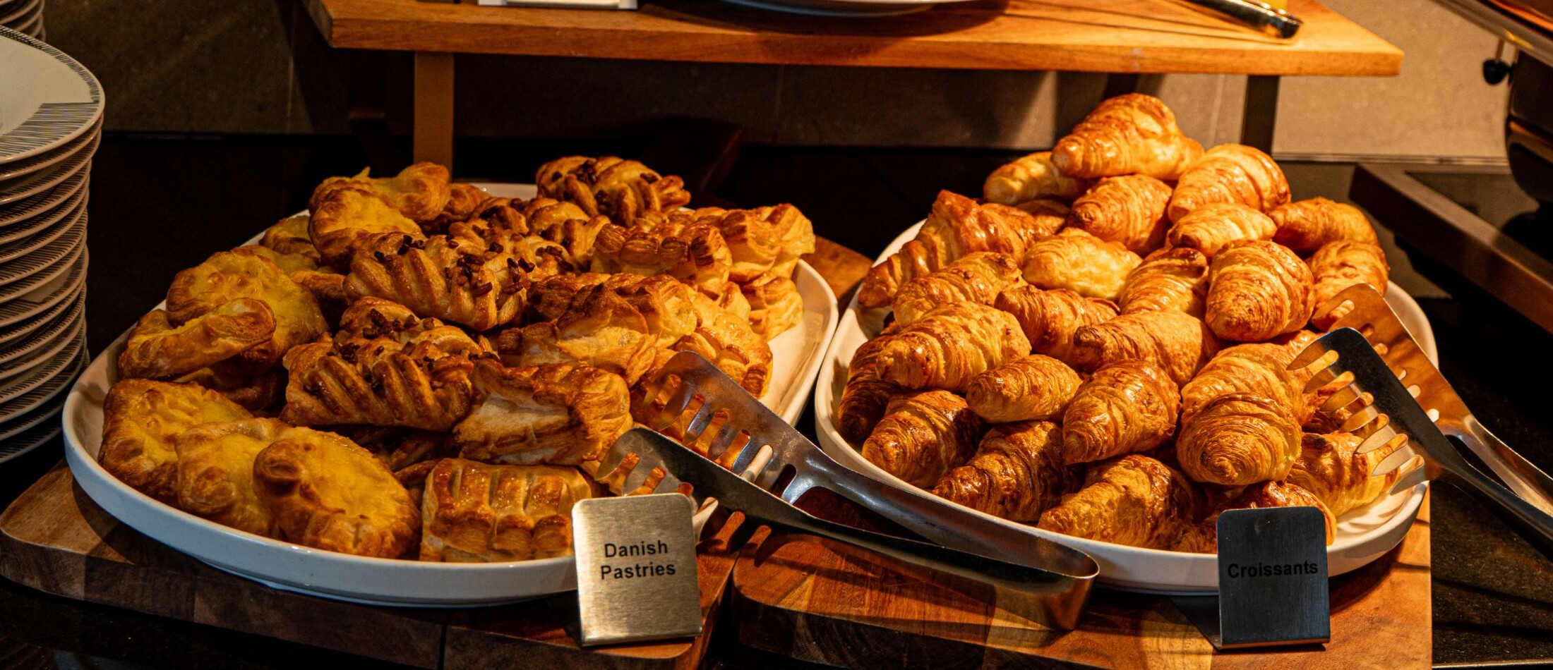 Assorted pastries displayed on trays, including croissants and baked goods, at Comfort Resort Leura Gardens.